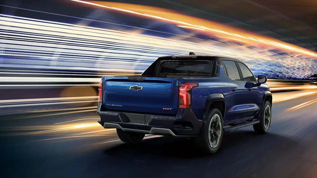We see a blue 2024 Chevy Silverado EV pickup truck with tunnel lights zooming by. 