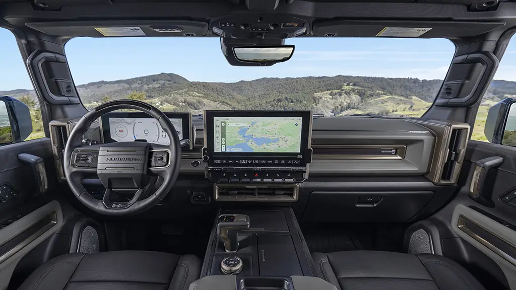 We see the inside of a 2024 Hummer EV SUV highlighting the infotainment center and large windsheild.