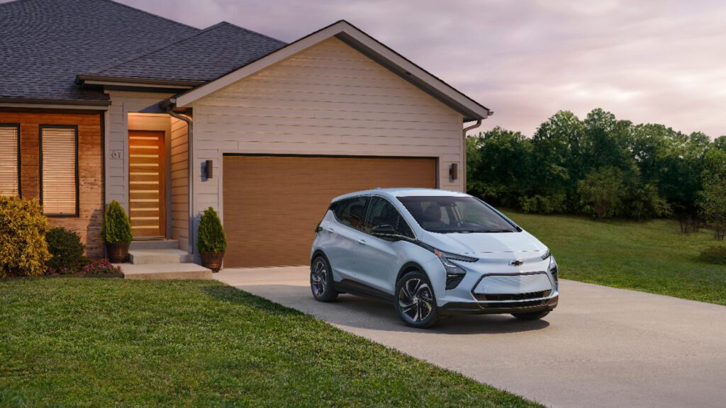 2023 Chevy Bolt parked in front of attached garage