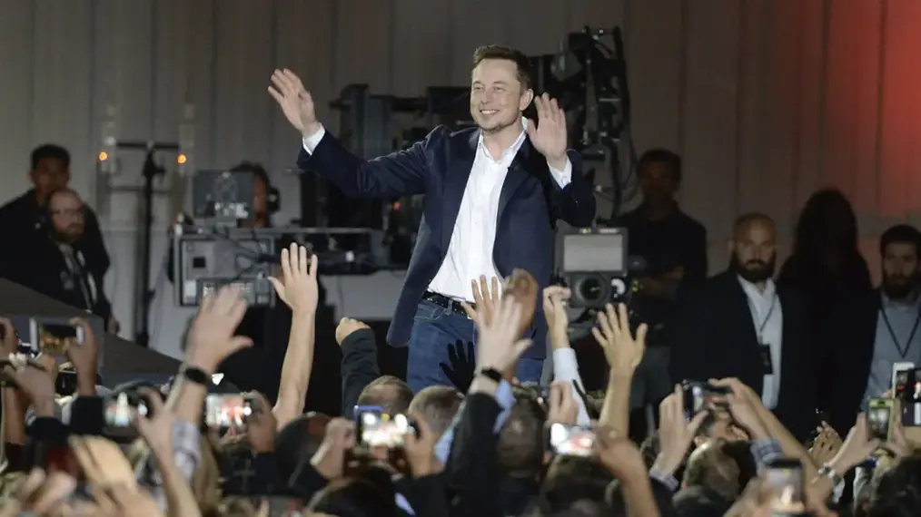 Elon Musk greets his fans at an event.