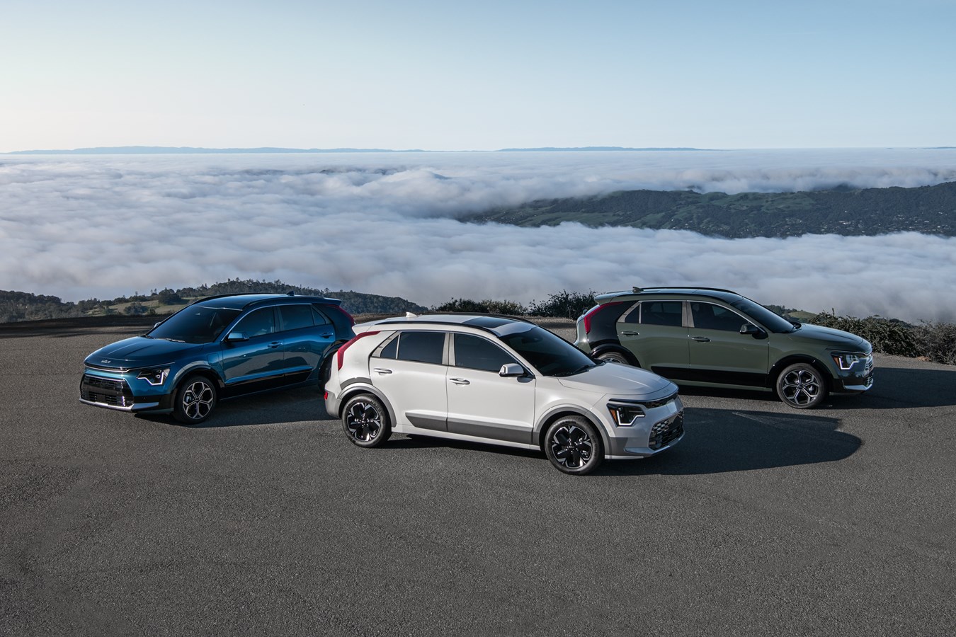 3 2024 Kia Niro compact crossovers on a mountain ledge overlooking the clouds